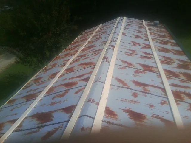 Rusted metal roof panels with new wood purlins before replacement — Storm Damage Roof Repair in Levittown by Roofing Brothers
